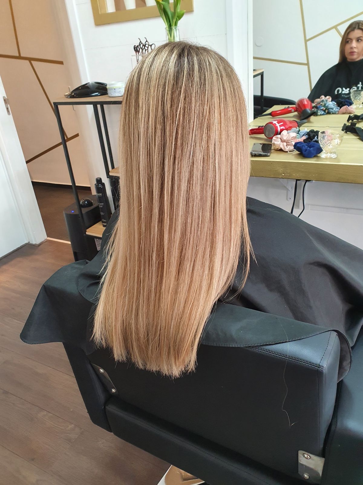 Lang, steil beigeblond haar in de salonstoel